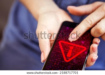 Mobile phone in female hands with screen showing compromised virus infected device. Cyber attack. Royalty-Free Stock Photo #2188717701