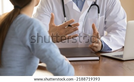 Close up doctor therapist consulting female patient at meeting, sitting at work table with laptop, physician gp explaining, giving recommendation at medical appointment, healthcare insurance concept Royalty-Free Stock Photo #2188719393