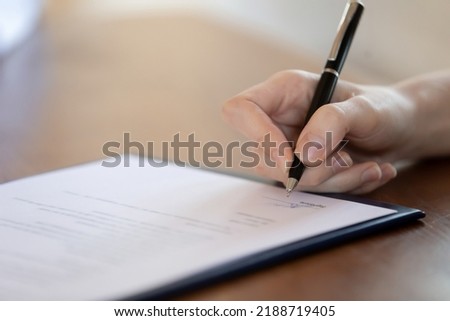 Close up woman holding pen, signing document, client customer making medical insurance or purchasing deal, putting signature on agreement after successful negotiations with lawyer, advisor, realtor