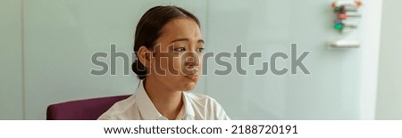 Sad asian business woman sitting on her workplace in office. High quality photo