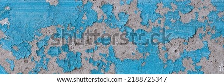 Peeling paint on the wall. Panorama of a concrete wall with old cracked flaking paint. Weathered rough painted surface with patterns of cracks and peeling. Wide panoramic grunge texture for background Royalty-Free Stock Photo #2188725347