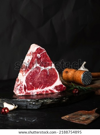 Dry-aged Raw T-bone or porterhouse beef meat Steak with herbs and salt. dark background. 