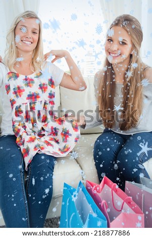 Composite image of Girls looking at the camera as they try new clothes with snow falling
