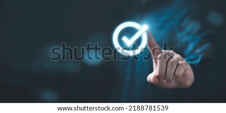 Businessman hand touching glowing correct sign mark with copy space area for document approval and project approve concept.