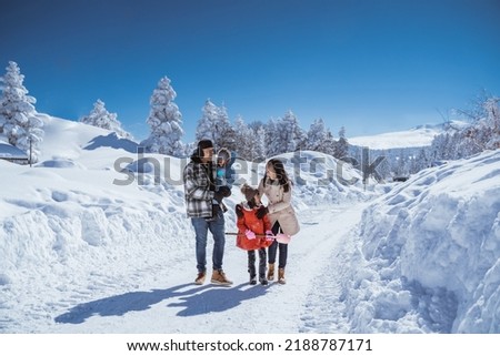 family walking together in winter with beautiful snow all over the place