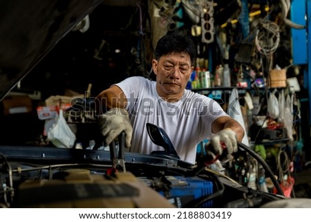 Man charging battery car with electricity cables. Engine engineer is charging car battery because car battery is depleted. concept car maintenance 