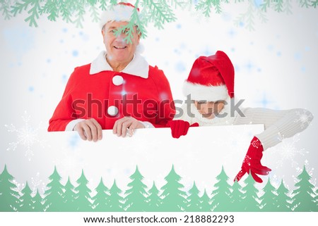 Festive older couple smiling and holding poster against frost and fir trees in green