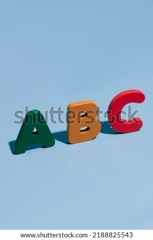 PADANG, INDONESIA - AGUST 11th, 2022 - Alphabet on pastel blue background. Eco-friendly, plastic-free set of accessories for kids. Toys for kindergarten, preschool or daycare