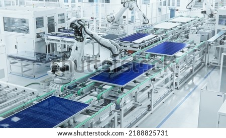 Wide Shot of Solar Panel Production Line with Robot Arms at Modern Bright Factory. Solar Panels are being Assembled on Conveyor. Royalty-Free Stock Photo #2188825731