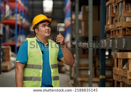 Asian salesperson, check stock and use radio for warehouse communication, business idea