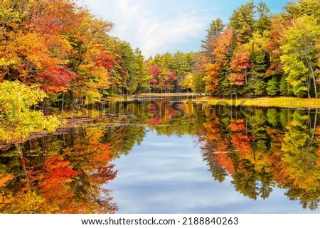 Autumn foliage reflections in calm pond water in New England Royalty-Free Stock Photo #2188840263