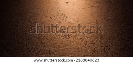 The rough-textured concrete patterned background on maroon wall provide a backdrop of bright light and shadow dark Royalty-Free Stock Photo #2188840623