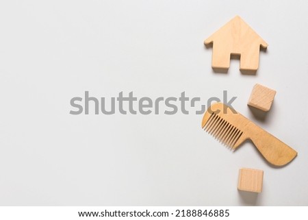 Wooden hair comb for baby, cubes and house on light background