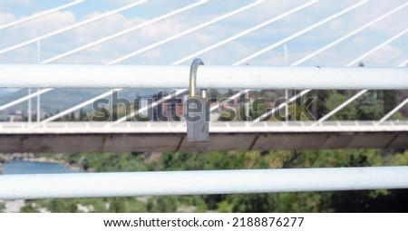 a metal lock on a bridge handle with another bridge in behind