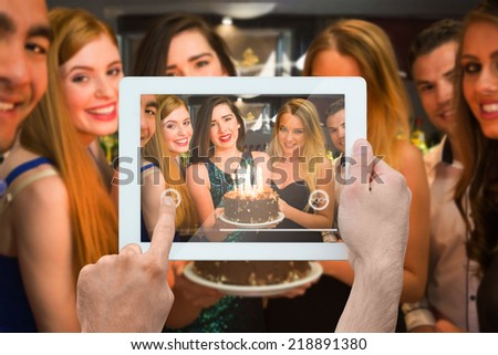 Composite image of hand holding tablet pc showing photograph