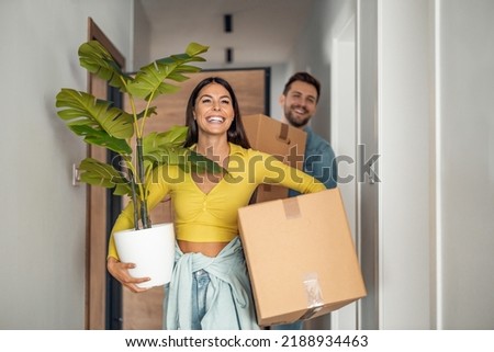 Young couple moving in new home.Couple is having fun with cardboard boxes in new house at moving day. Royalty-Free Stock Photo #2188934463