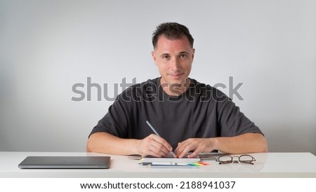 The guy at the desk makes notes in a notebook - study and work. High quality photo