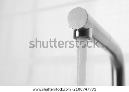 Stream of water flowing from tap on white background, closeup. Space for text