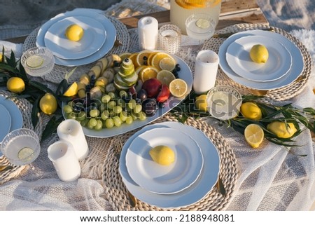 Romantic luxury picnic on the beach. Boho decoration with lemons. Bachleorette party, couple date, birthday party. 