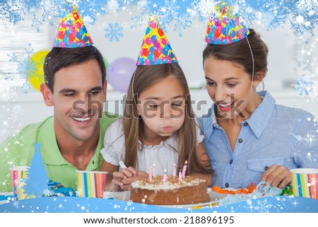 Composite image of little girl blowing out her candles against snow