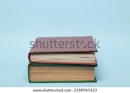 Stack of two books on a blue background Royalty-Free Stock Photo #2188965423