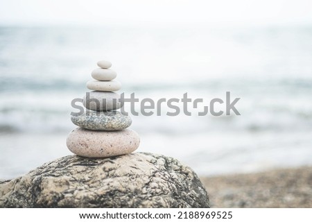 Pebble tower balance harmony stones arrangement on sea beach coastline. Relaxing peaceful formation pyramid cobblestone philosophy equilibrium spiritual tranquility. Spa therapy summer travel vacation Royalty-Free Stock Photo #2188969525