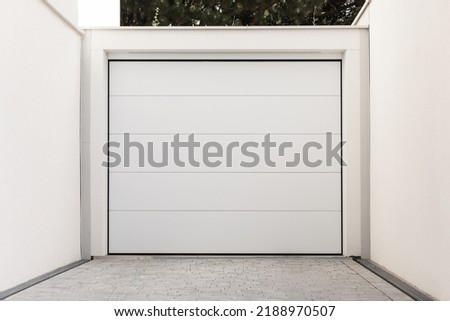 Lift gate to private yard. White wide doors between walls Royalty-Free Stock Photo #2188970507