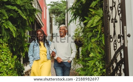 Happy senior couple laughing cheerfully while walking together outdoors. Cheerful senior couple spending some quality time together after retirement. Royalty-Free Stock Photo #2188982697
