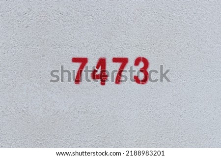 Red Number 7473 on the white wall. Spray paint.
