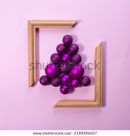 Christmas decorations lined Christmas tree on a pink background in a frame. Christmas concept.
