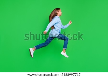 Full length profile photo of small girl running marathon sport competition wear stylish blue sweatshirt isolated on green color background