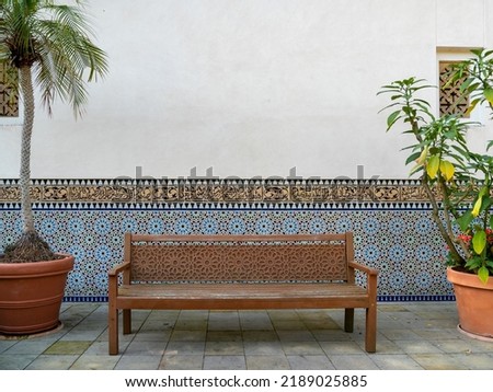 Wooden bench in the park against the wall. Carved bench. Royalty-Free Stock Photo #2189025885