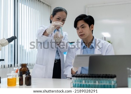 biochemical research scientist team working with microscope for vaccine development in pharmaceutical research labolatory.
