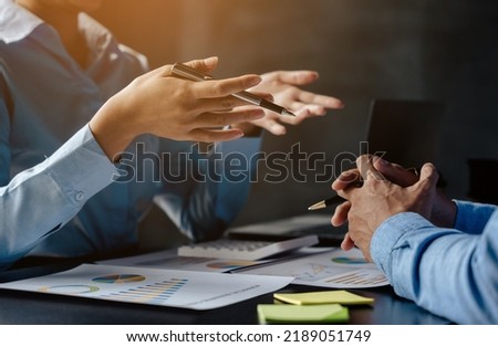 Close up of hands are working and brainstorming on paperworks about business financial and marketing with ray light. Royalty-Free Stock Photo #2189051749