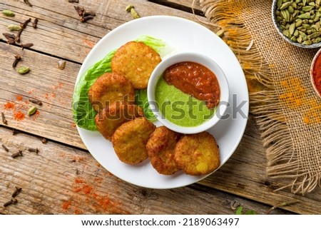 Alu Tikki with cheese and tomato mint sauce with indian spices, indian cuisine on old wooden table Royalty-Free Stock Photo #2189063497
