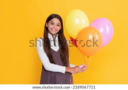 smiling girl with party colorful balloons on yellow background