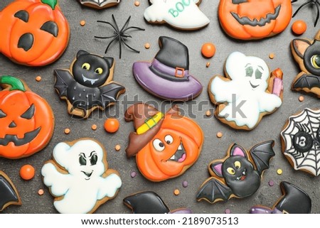 Tasty cookies and sweets for Halloween party on black table, flat lay