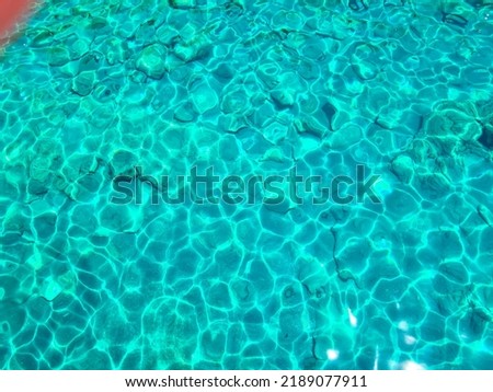 Turquoise surface of transparent sea water with sun glints Royalty-Free Stock Photo #2189077911