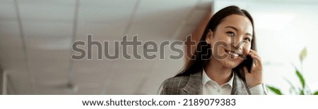 Asian business woman making a phone call and smiling at office. High quality photo