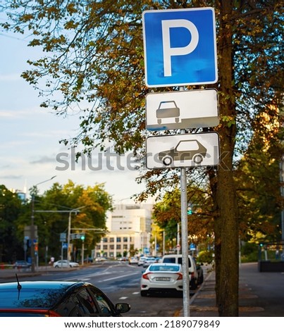 Cars in parking zone at roadside in the city. Parking lot sign, one free parking space, cars in parked zone, evening car park