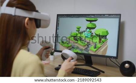 Asian Female Freelancer Working with Inspiration in her Studio. Concentrated Woman Creating her Own Project, She using VR to Control her Games Project by 3D Animation Software.