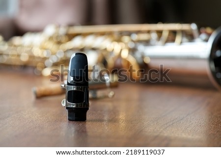 Soprano Saxophone Mouthpiece, Closeup Woodwind Instrumental Equipment on Blur Saxophone Background. Royalty-Free Stock Photo #2189119037