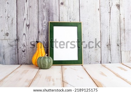 Autumn and Halloween concept. Portrait frame against a light wall. Frame with pumpkins and space for text.