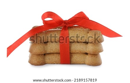 Bone shaped dog cookies with red bow isolated on white Royalty-Free Stock Photo #2189157819