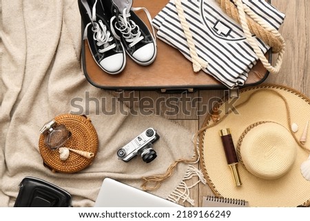 Accessories for travelling with photo camera on wooden background