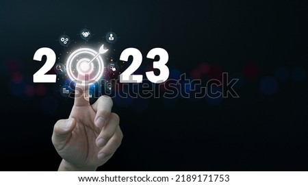 Finger pressing blue start 2023 button on virtual interface on gray background with copy space for text. Concept of new year. Businessman pressing 2023 start up business. Beginning of New Year 2023 Royalty-Free Stock Photo #2189171753
