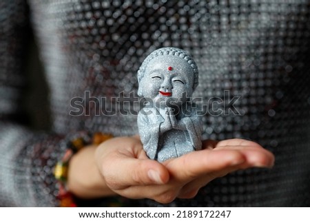 Woman with a buddhist monk figurine in her hand. Ho Chi Minh City. Vietnam.
