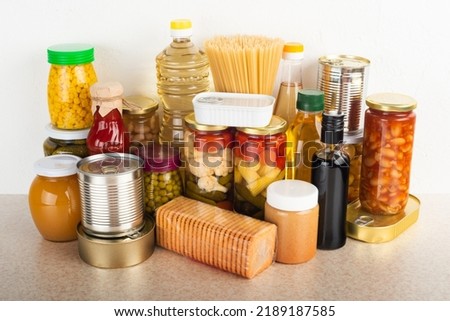 Emergency survival food set on white kitchen table Royalty-Free Stock Photo #2189187585