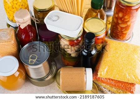 Emergency survival food set on white kitchen table high angle view Royalty-Free Stock Photo #2189187605