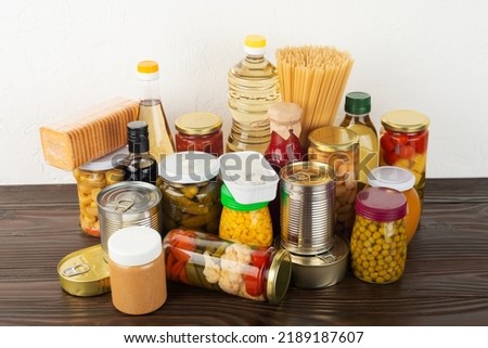 Emergency survival food set on dark wooden kitchen table Royalty-Free Stock Photo #2189187607